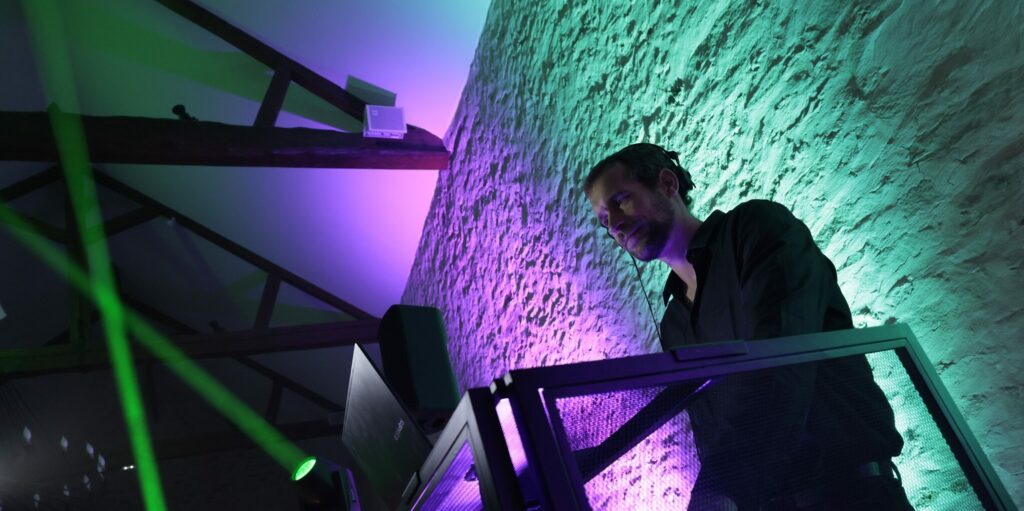DJ événementiel professionnel avec éclairage architectural lors d’une soirée premium en Île-de-France