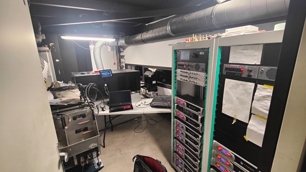 Interconnexion audio dans la cabine de projection du cinéma avec racks d'amplificateurs Crown et projecteur Barco.