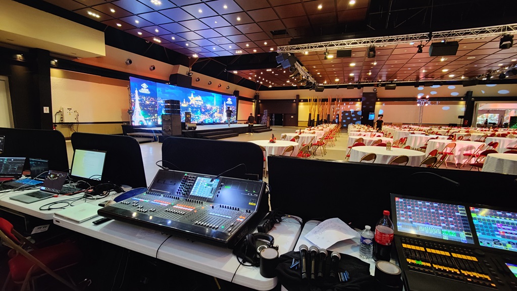 Régie technique avec console Yamaha CL5 et mur LED géant lors d'une convention d'entreprise en configuration tables rondes.