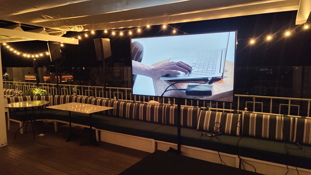 Écran TV grand format et enceinte Yamaha installés sur un rooftop pour un cocktail d'entreprise T.E.P.