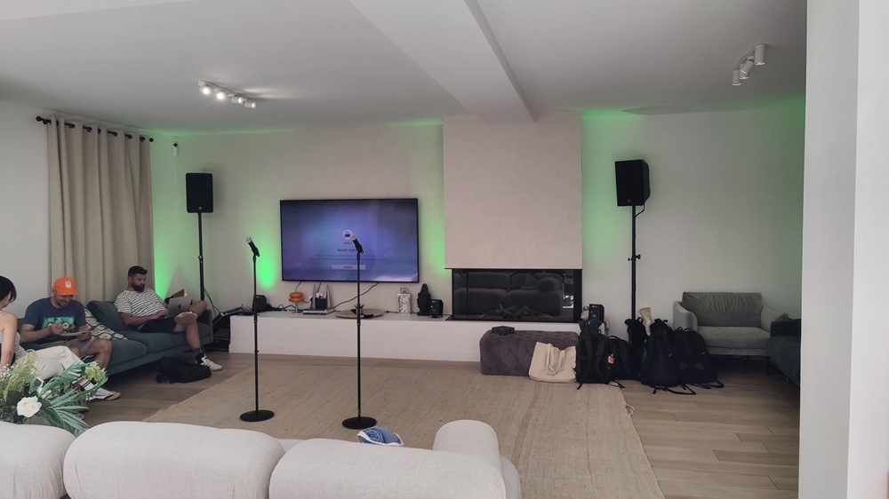Espace karaoké d'entreprise avec micros HF sur pieds et projecteurs PAR LED de couleur T.E.P. dans un salon